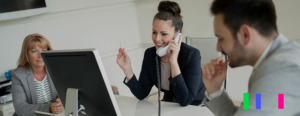 Equipe de vendas em frente a uma mesa conversando no telefone