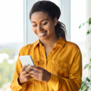 Mulher sorridente usando o celular.
