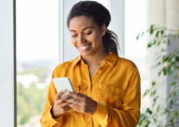 Mulher sorridente usando o celular.