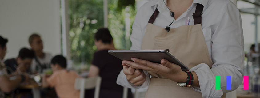 Mulher em um PDV segurando um tablet.