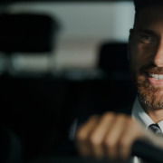 Imagem de um homem de terno dirigindo o seu carro