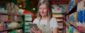 mulher mexendo no tablet dentro de um supermercado