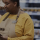 Promotora de vendas vendo conferindo o PDV do supermercado com o aplicativo de trade marketing
