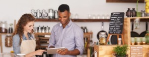 Homem e mulher segurando um tablet em um estabelecimento comercial