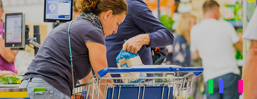 Foto de pessoas colocando produtos no carrinho de supermercado