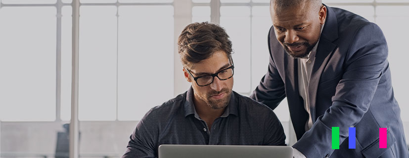 Dois homens no escritório olhando para a tela do computador.