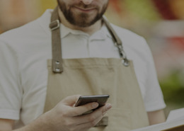 Homem no PDV analisando os produtos no celular