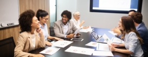 Pessoas diversificadas sentadas em volta de uma mesa de reunião