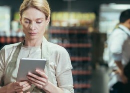 Promotora de vendas segurando um tablet.