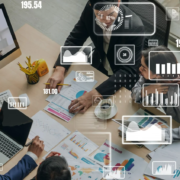 Dois executivos discutindo sobre um sistema ERP com força de vendas, enquanto observam tela de computador mostrando o software.