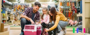 Homem, mulher e criança brincando com um cachorro.