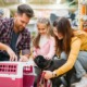 Homem, mulher e criança brincando com um cachorro.