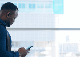 Homem de terno usando um celular.