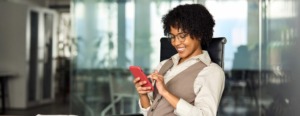 Mulher sentada mexendo no celular em um Aplicativo-de-venda-para-atacado-distribuidor